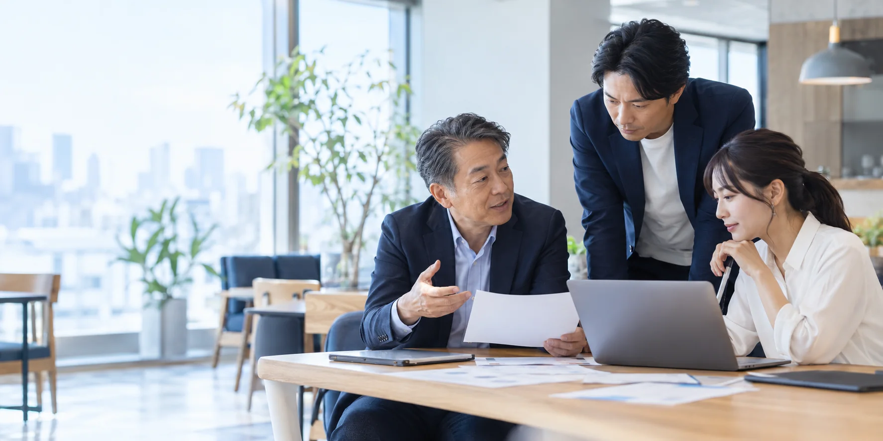 経営者と管理職が資料を見ながら話し合うイメージ